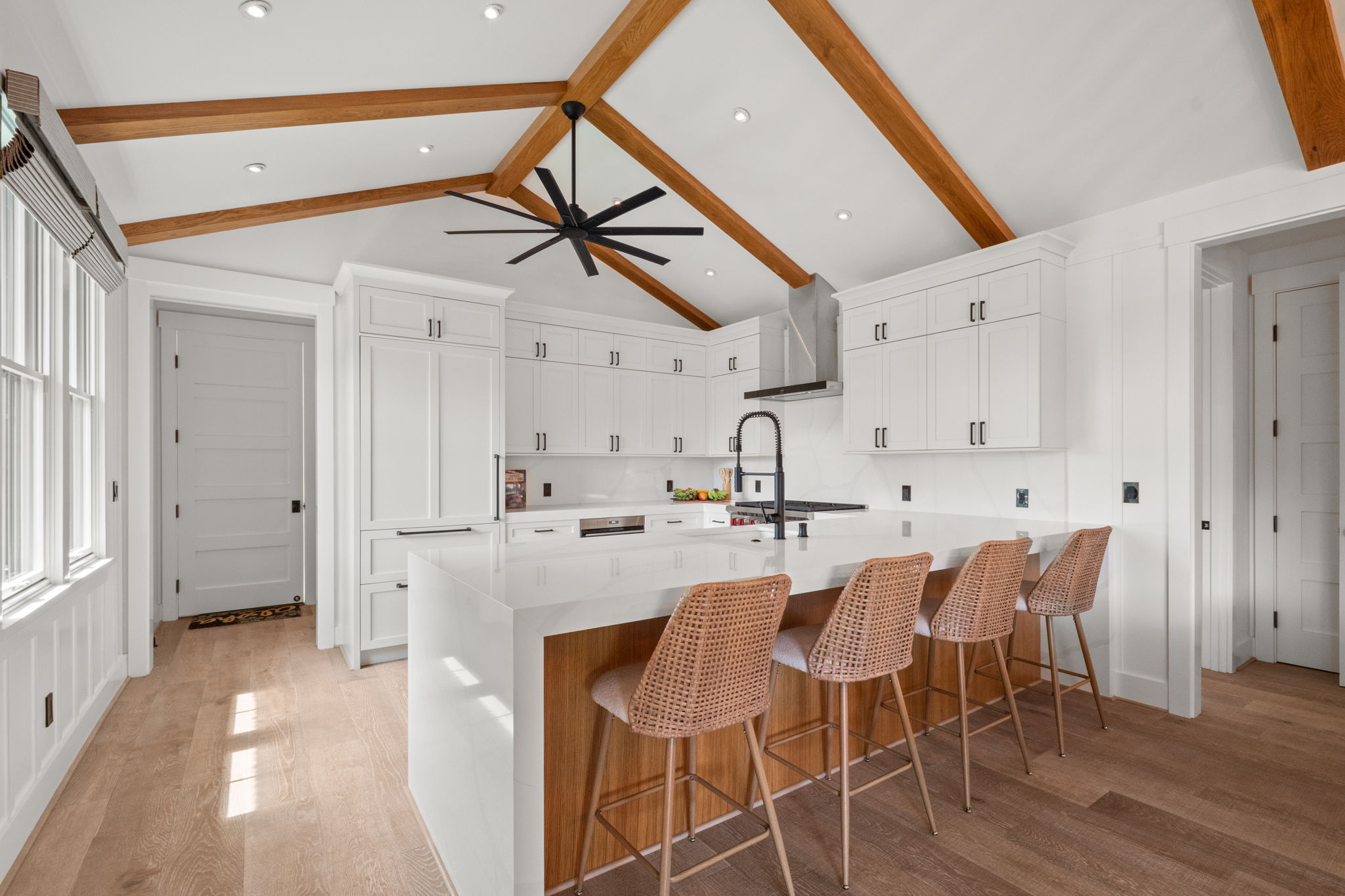 Kitchen with island, woven barstools, and vaulted ceiling