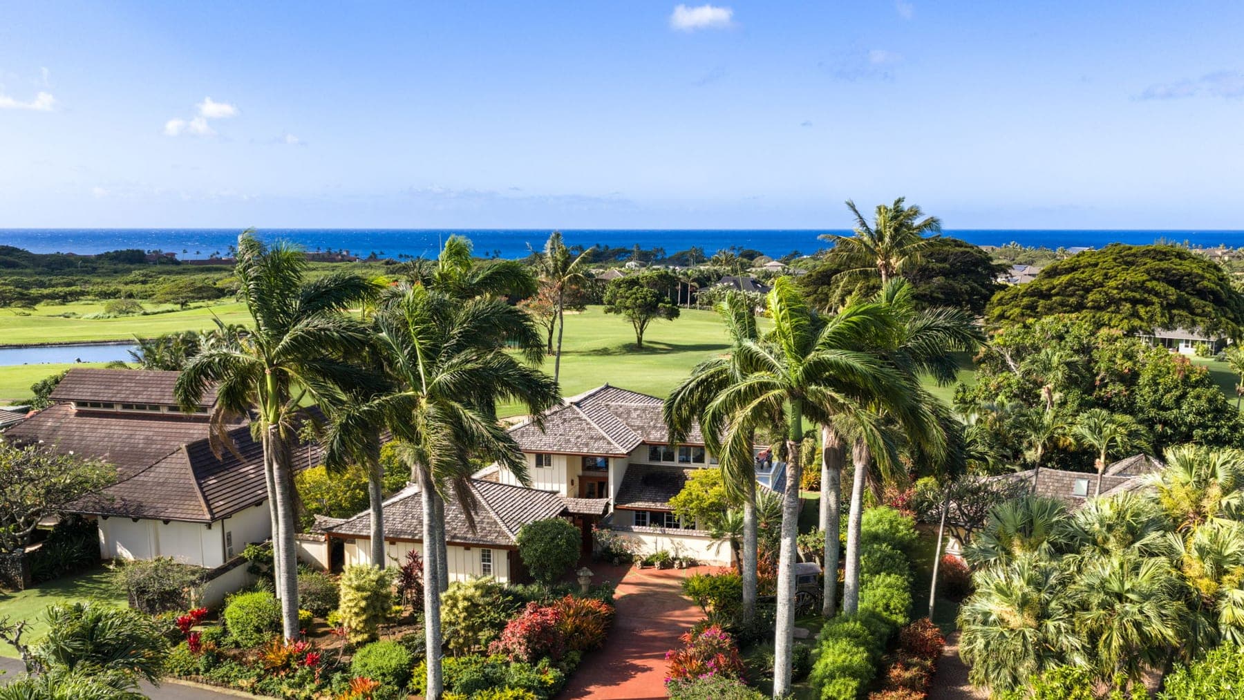 Aerial view of Kiahuna Golf Village homes along the golf course fairways with the Pacific Ocean beyond, Poipu, Kauai